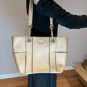 NWOT Pale gold colored Calvin Klein purse with gold metal accents.